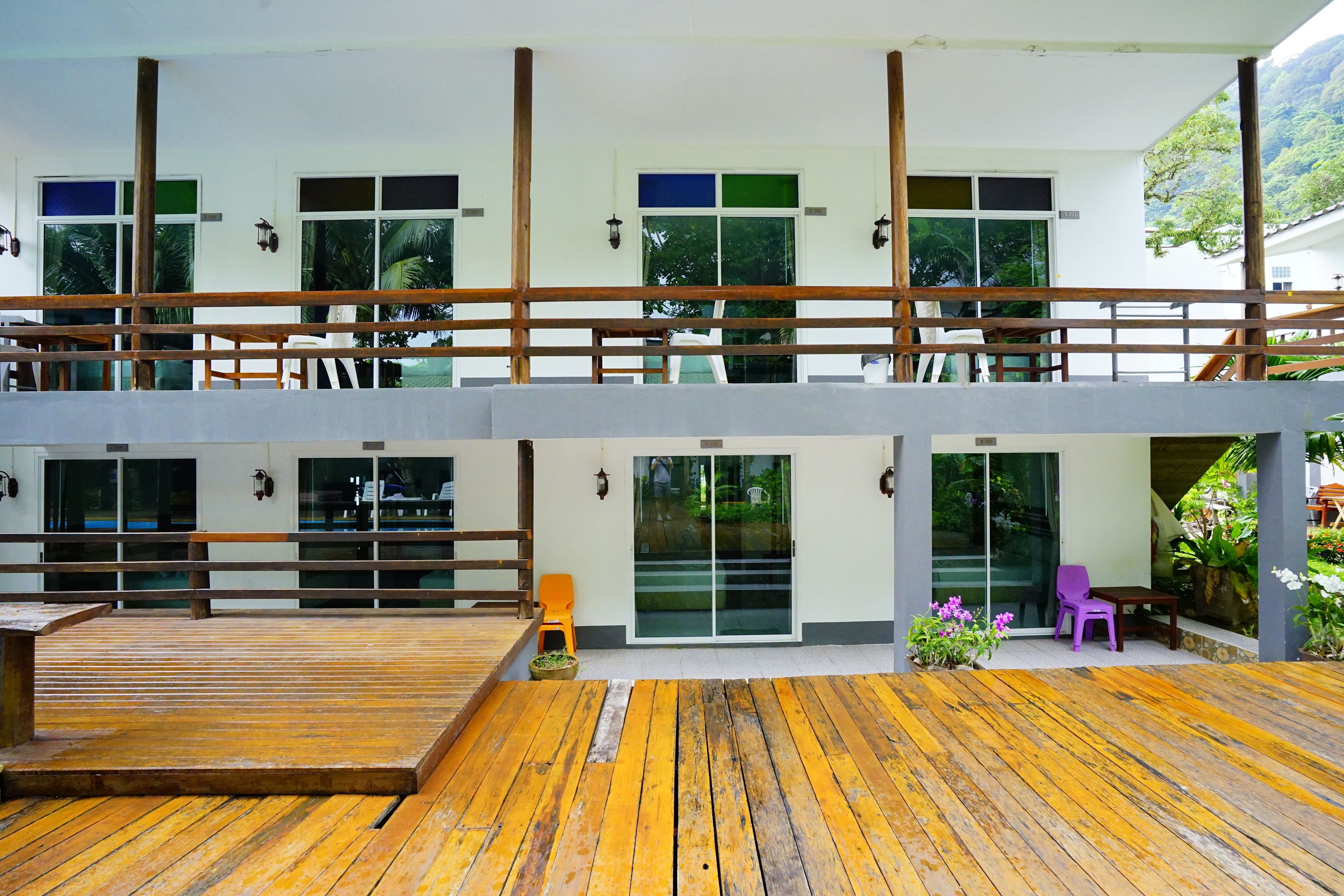 A two-story building with a wooden deck and a balcony.