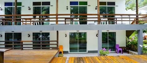 A two-story building with a wooden deck and a balcony.