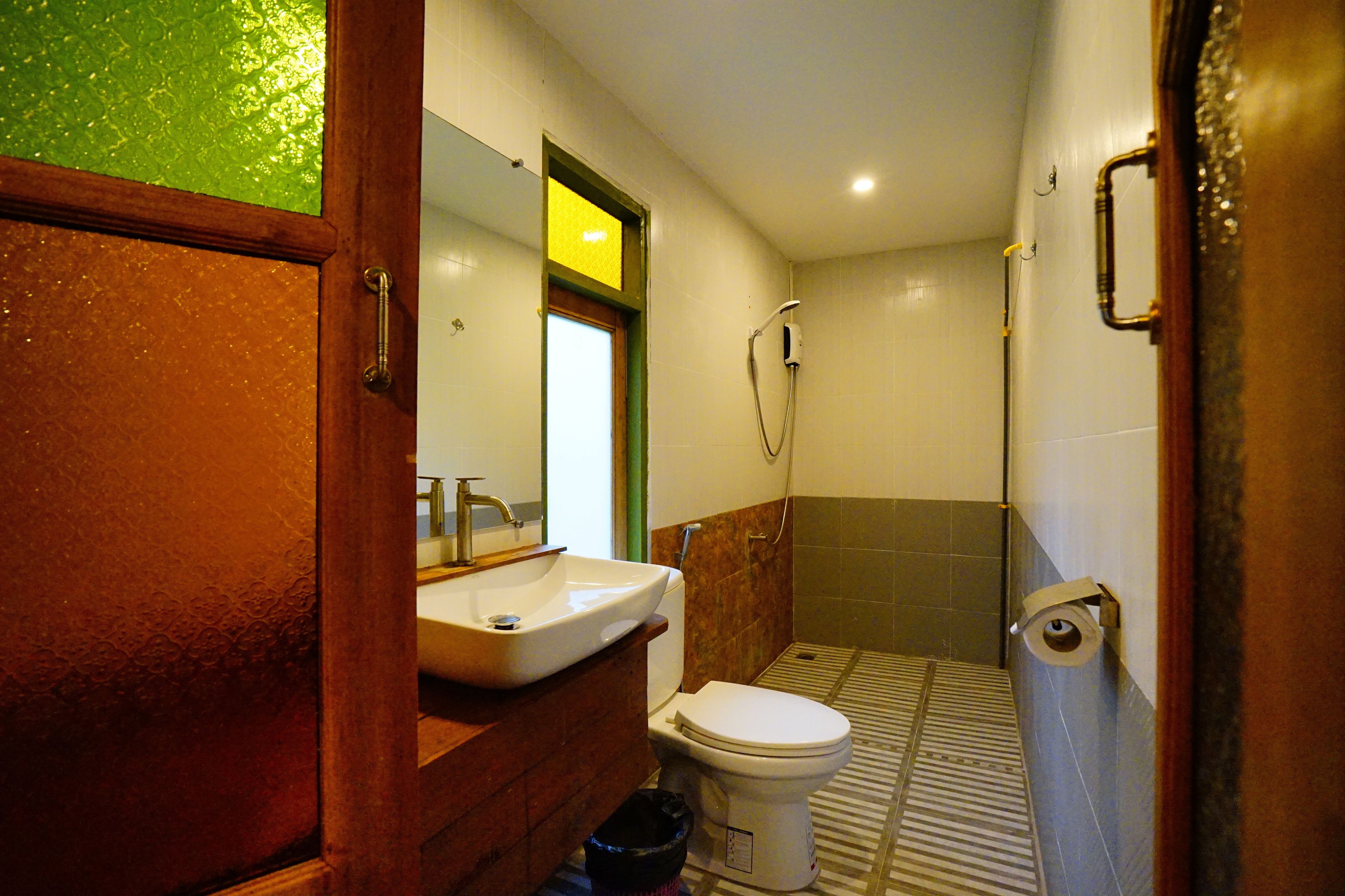 Een badkamer met wastafel, toilet en douche.