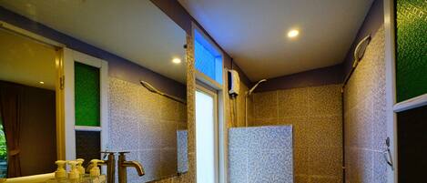 A bathroom with a large sink, toilet, and shower area.
