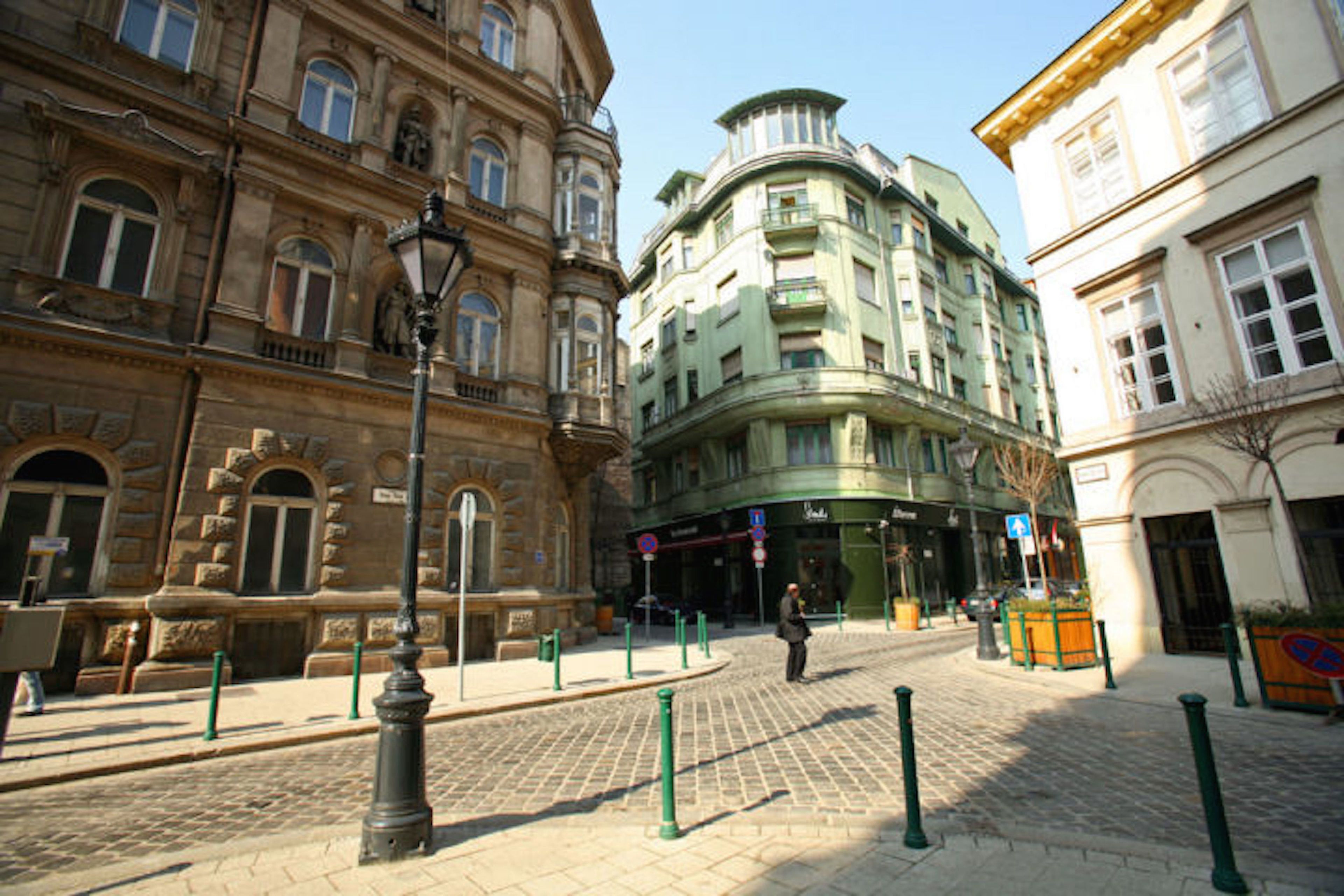 Ein Kopfsteinpflasterplatz mit historischen Gebäuden, einer Straßenlaterne und Leitpfosten.