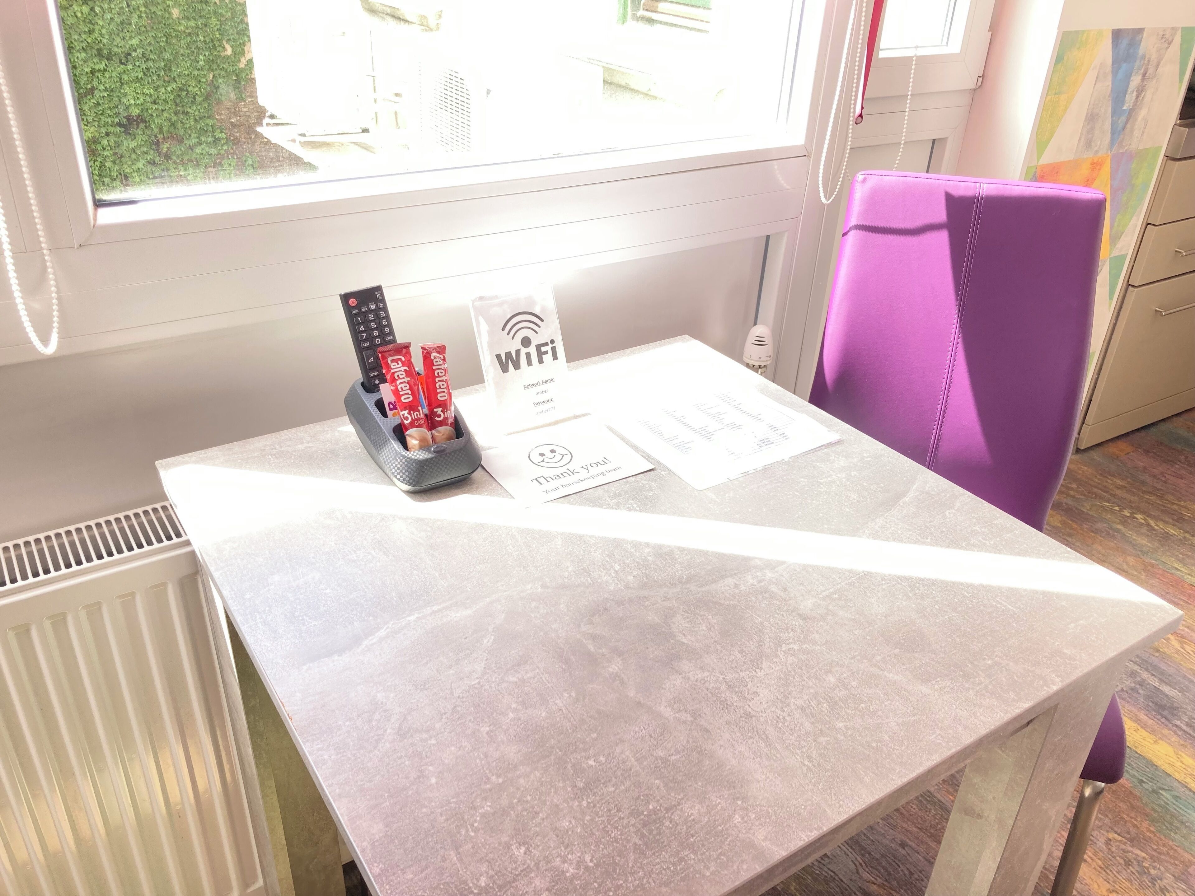 A table with a remote control, a Wi-Fi sign, and a menu card.