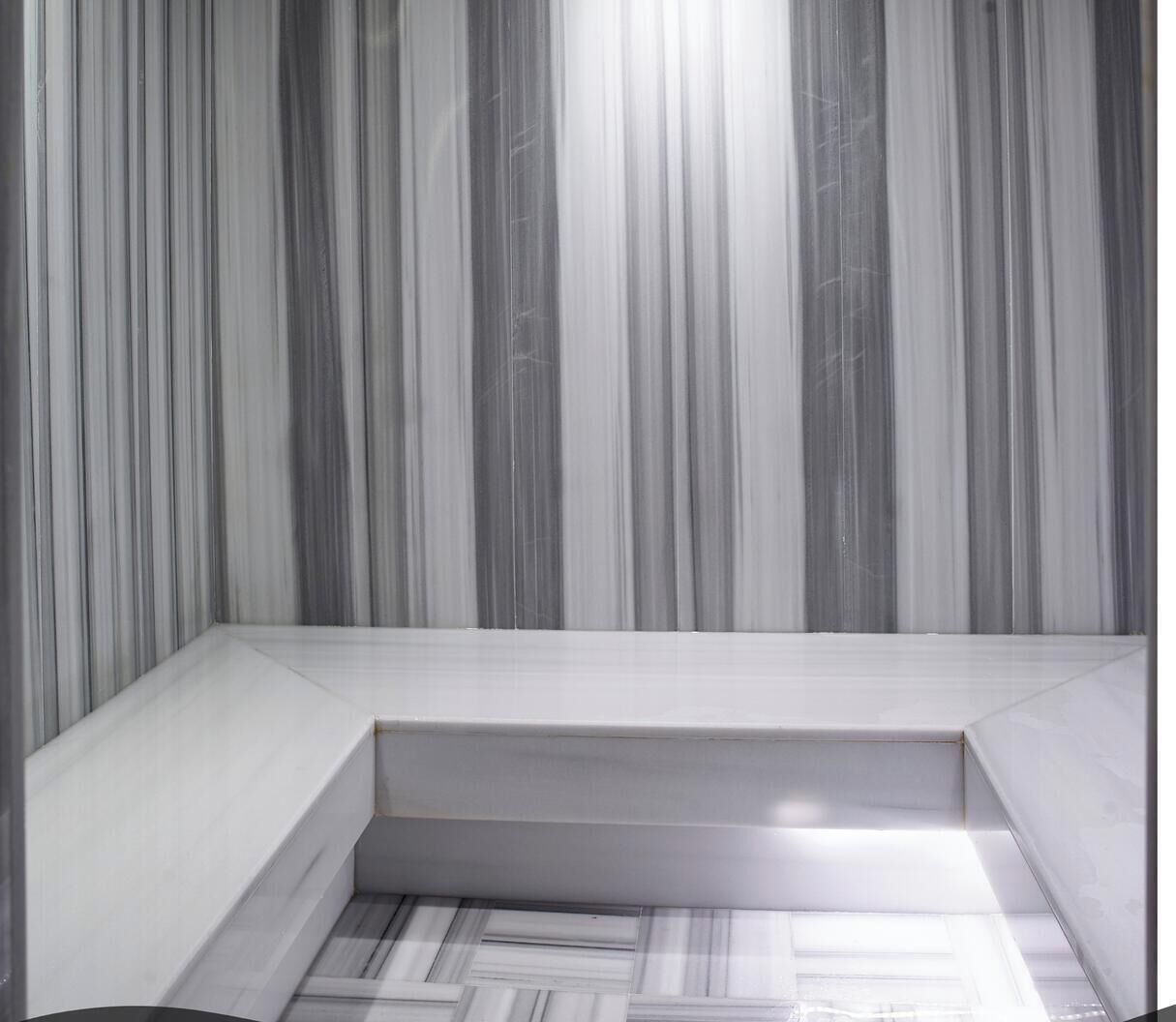 A room with a sloped ceiling and a built-in bench along the wall.