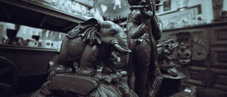 A room with a statue of an elephant and a figure holding a staff.