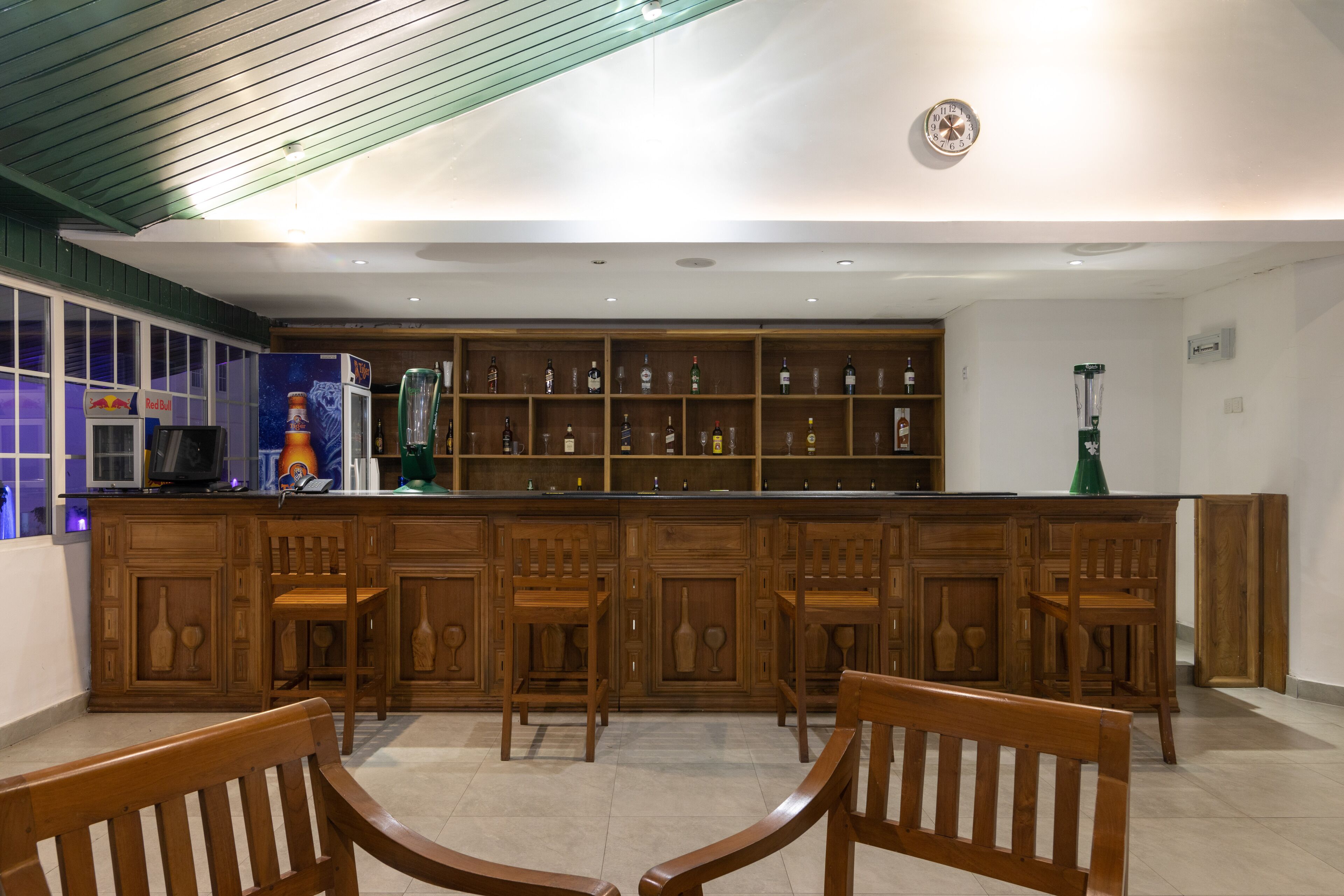 Un espace bar avec des meubles de rangement en bois et des tabourets de bar.
