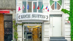 A hotel entrance with the name "Luce Suites" and multiple flags. - Luce Suite Hotel (Istanbul)