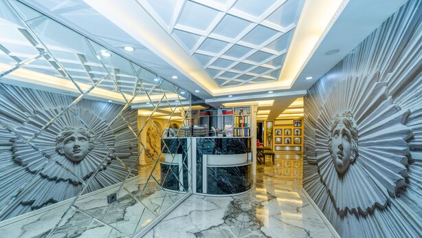 A luxurious lobby with marble floors, a glass staircase, and ornate wall decorations. - Luce Suite Hotel (Istanbul)