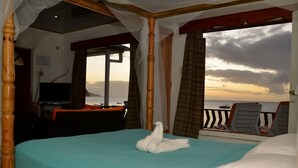 A room with a bed, a TV, and a view of the sea. - The Naturalist Beach Resort (Castara)
