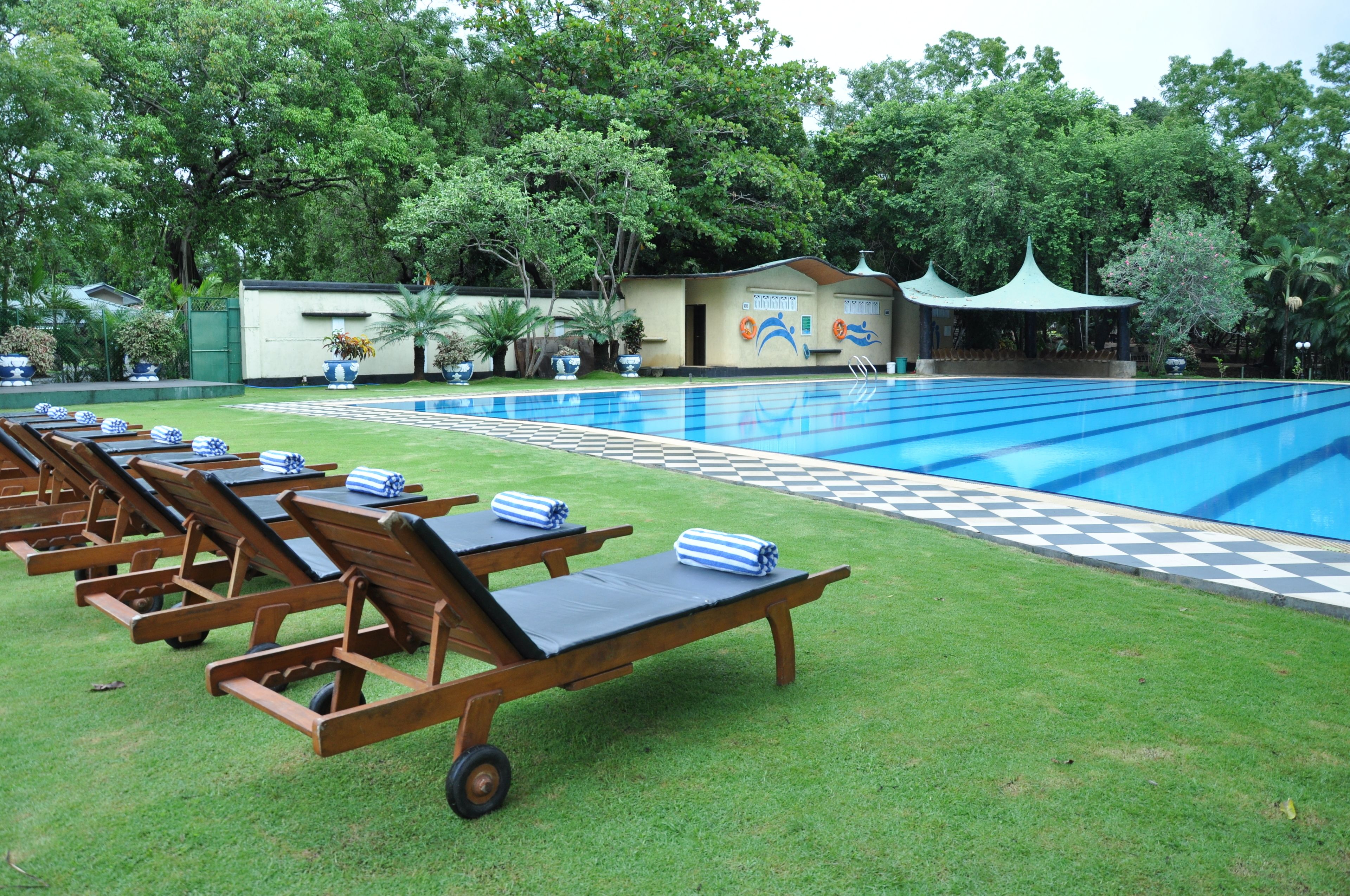 Une piscine avec des chaises longues et un pavillon.