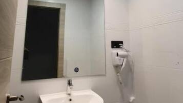 Een badkamer met een witte wastafel, spiegel en toilet.