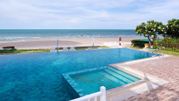 A clear blue infinity pool with a view of the beach and ocean. - Baan Poolom Beachfront Condominium (Hua Hin)