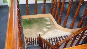 A wooden staircase with a view of a small garden area below. - Beach Lagoon Guesthouse (Tangalle)