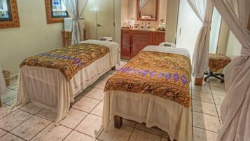 Two single beds, a dresser, and a table with chair are featured in this hotel room.