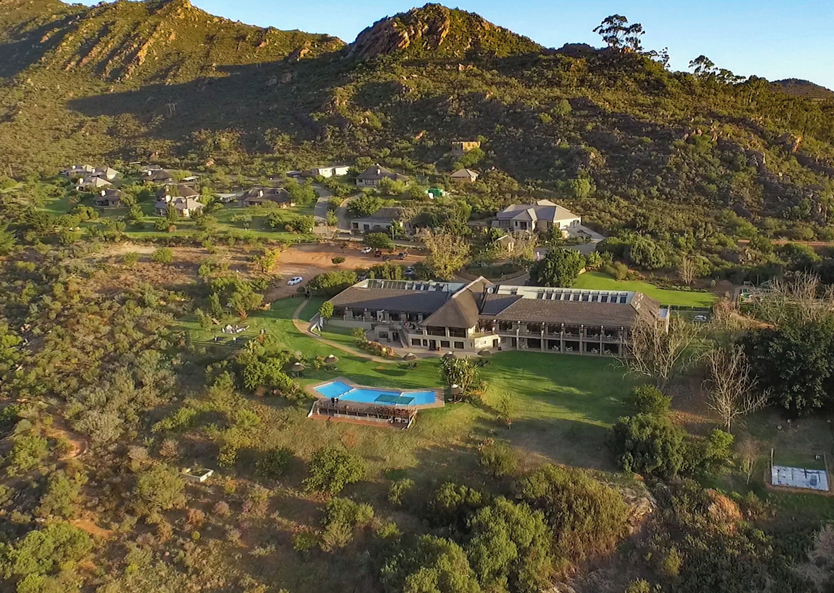 A large resort with multiple buildings, a swimming pool, and a golf course.