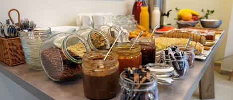 A buffet table with various food items and condiments.