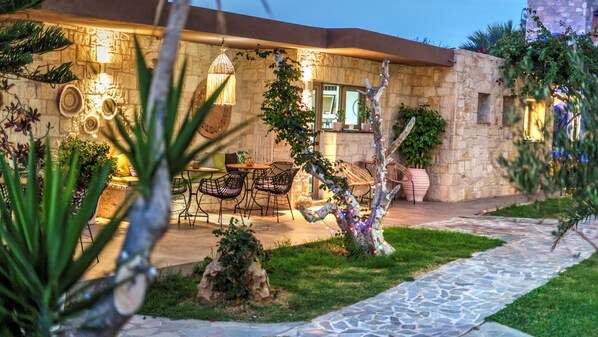 A stone building with a patio area featuring outdoor seating and a stone pathway.