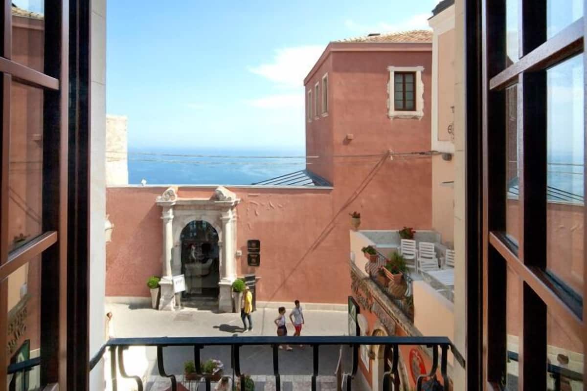 Ein Balkon mit Blick auf das Meer und angrenzende Gebäude.