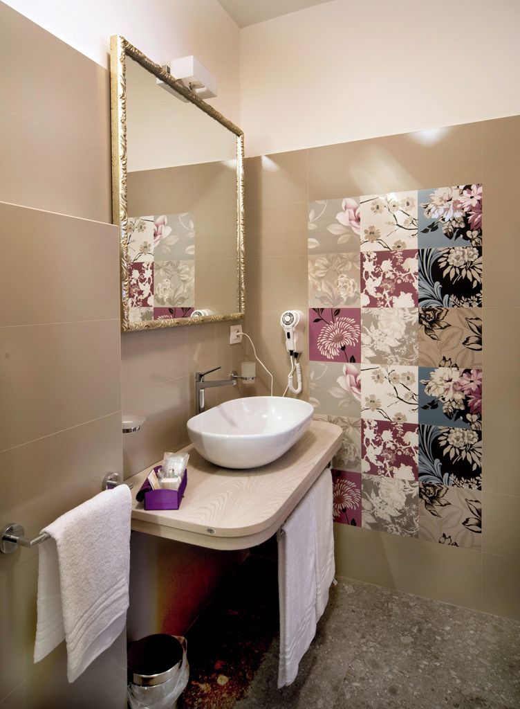A bathroom with a white sink, a mirror, and a shower area.