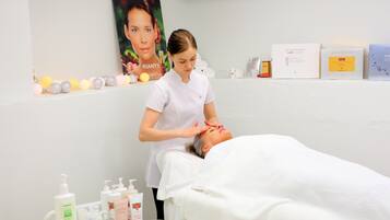 Experience rejuvenation with a soothing facial treatment in a serene spa setting, complete with a treatment bed and a selection of skincare products.