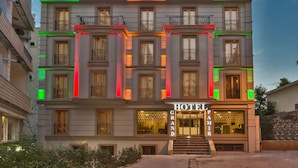 A hotel with a grand entrance, multiple balconies, and a prominent sign. - Grand Pamir Hotel (Istanbul)