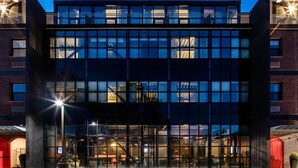 A modern building with a glass facade, a red door, and a staircase leading to the entrance. - Hotel Nyack, a JdV by Hyatt Hotel (Nyack)