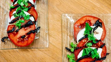 Dos platos de vidrio con ensalada de tomate y mozzarella.