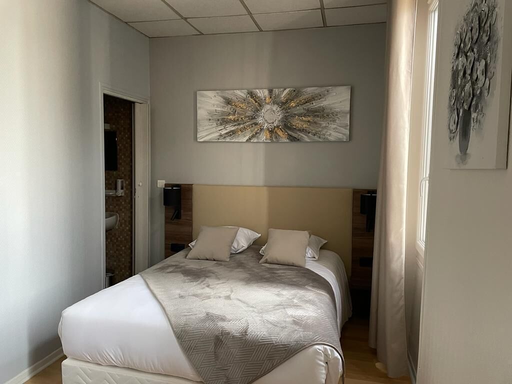 A modern bedroom with a large bed, a headboard, and a wall-mounted abstract painting.
