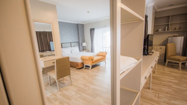 A hotel room with a bed, a desk, a chair, a TV, and a wardrobe. - Romance Hotel Srinakarin (Bangkok)