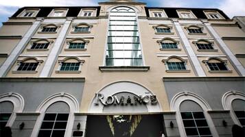 A building with a large arched window and the word "ROMANCE" on the facade.