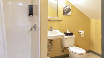 A bathroom with a toilet, sink, and shower.