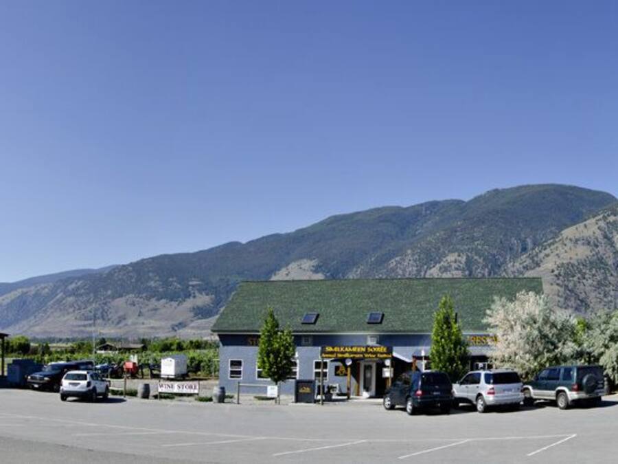 Un edificio con garaje, un letrero que dice 'The Lodge', y un estacionamiento con coches.