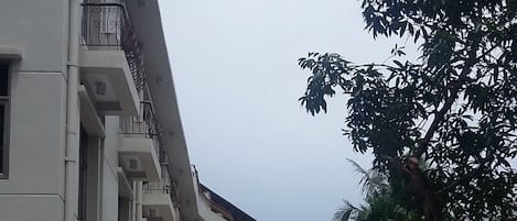 La entrada del Hotel Aeropuerto, con un camino de baldosas y un cartel.