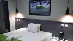 A hotel room with a bed, a desk, a telephone, and a wall-mounted picture. - Hotel Recanto das Perdizes (São Paulo)