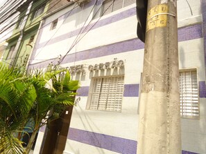A building with a sign reading "HOTEL CARAÓ" and a window with barred security. - Hotel Carrao (São Paulo)