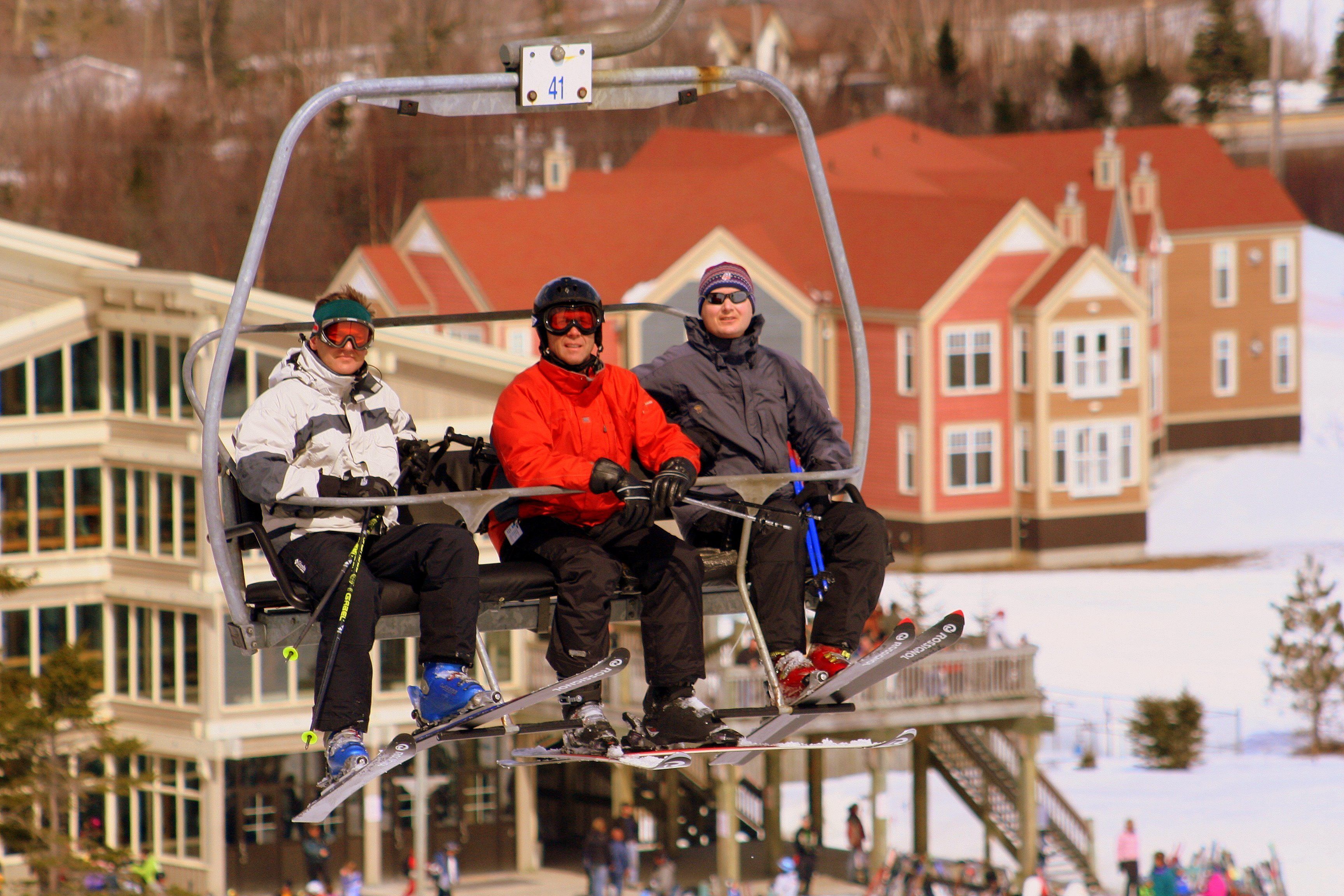 A ski lift with three skiers.