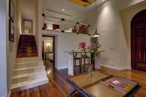 Eine Treppe führt zu einer zweiten Etage, einem Essbereich mit Tisch und Stühlen sowie einer Holztür.