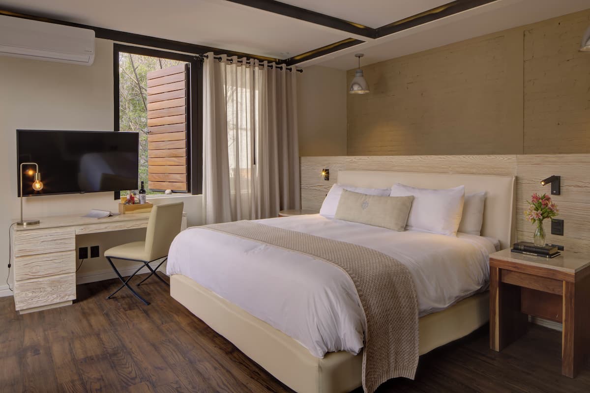 Une chambre moderne avec un grand lit, un bureau et une télévision.