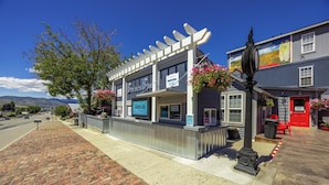 A building with a closed sign, a brick sidewalk, and a street view. - Deep Water Inn (Chelan)
