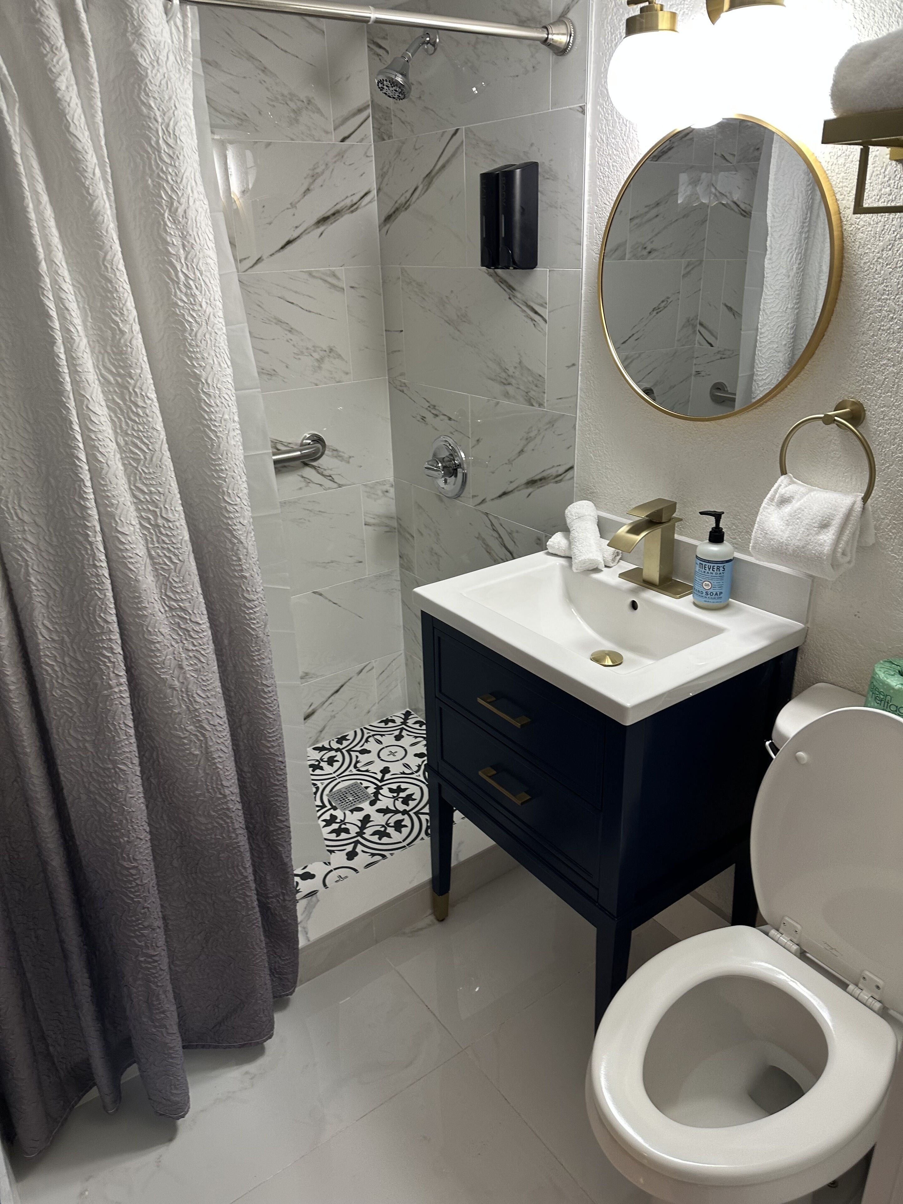 Ein Badezimmer mit Dusche, Toilette und Waschbecken.