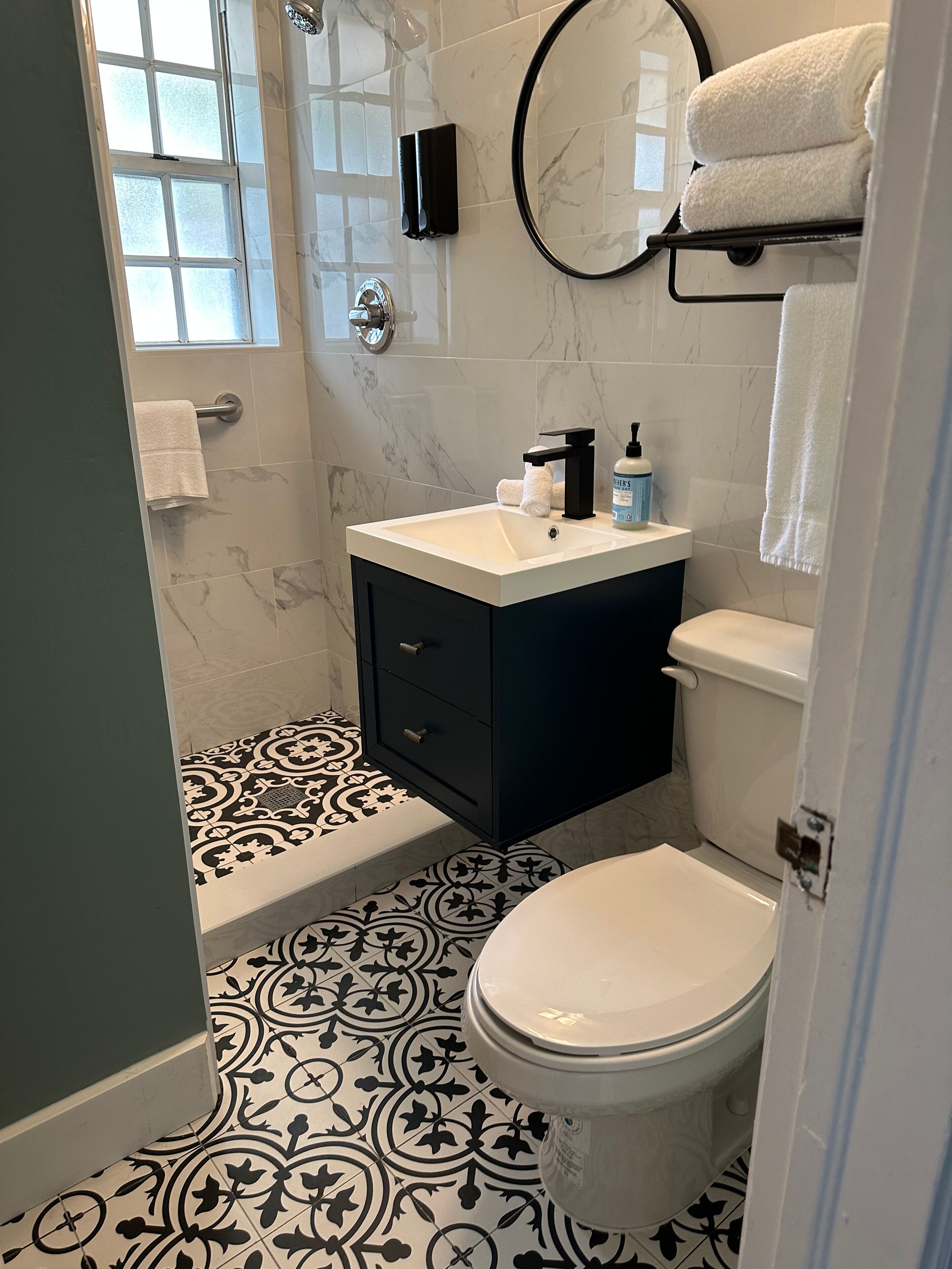 A bathroom with a toilet, sink, and shower.