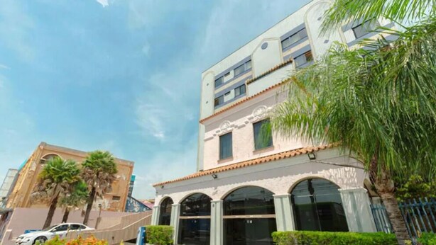 A multi-story building with a modern architectural style, featuring arched windows and a flat roof.