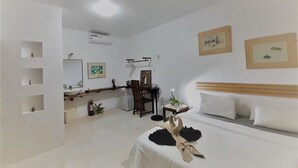 A hotel room with a bed, a desk, a chair, a mirror, and a sink. - Boracay Water World Resort (Boracay Island)
