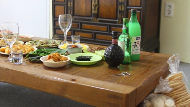 Una mesa de comedor con diversos platos, vasos y botellas.
