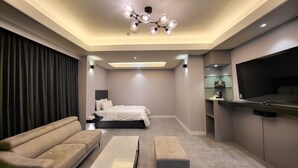 A modern bedroom with a bed, a sofa, a coffee table, and a TV. - Browndot Gwangju Sangmu (Gwangju)
