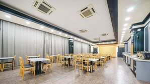 A spacious dining area with multiple tables and chairs, a kitchen area with modern appliances, and a large window providing natural light. - Browndot Gwangju Sangmu (Gwangju)