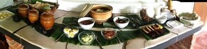 A table with various food items and containers, possibly for a meal or event. - The Roots Eco Resort (Ipoh)