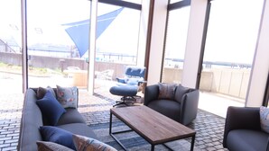 Un espace extérieur moderne aménagé avec un canapé, des fauteuils et une table basse.