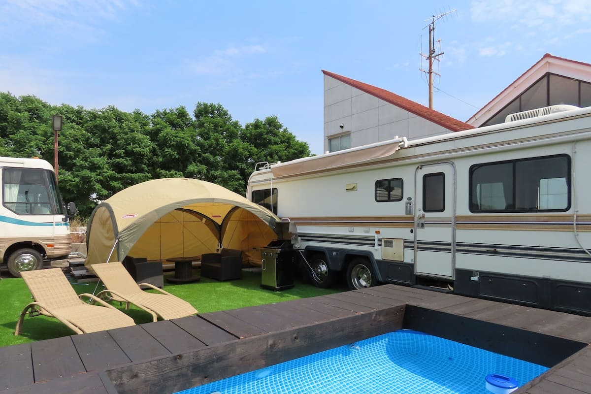 Un espace de camping équipé d’une piscine, de tentes et d’emplacements pour camping-cars.