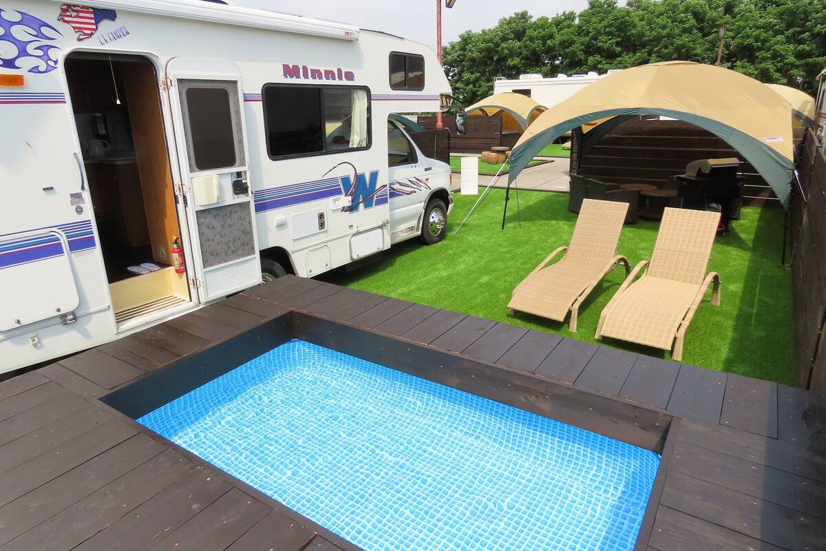 Un espace de loisirs comprenant une piscine, des chaises longues et un espace de détente abrité.
