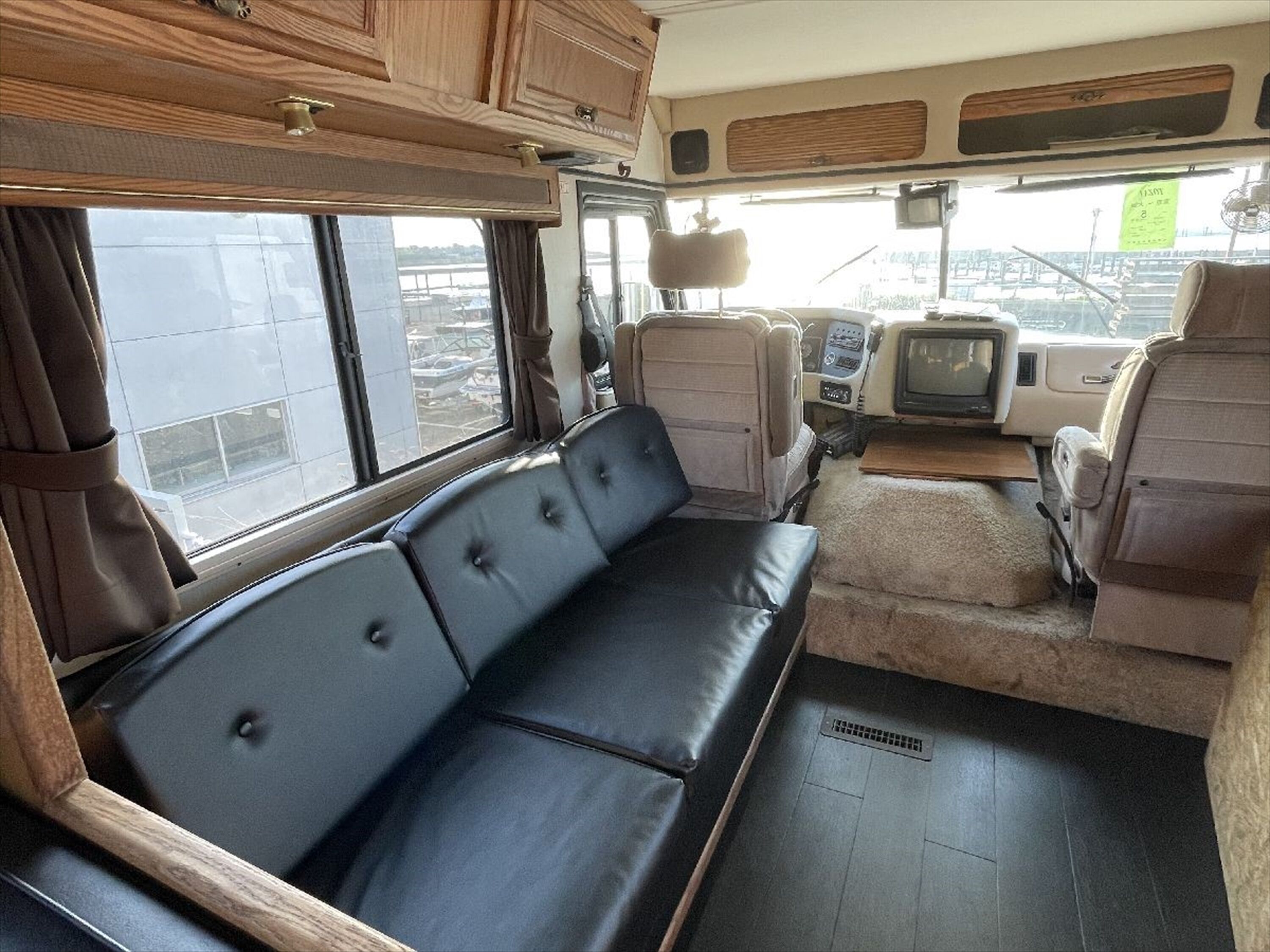 A compact RV interior with a sofa, a small table, and a television.